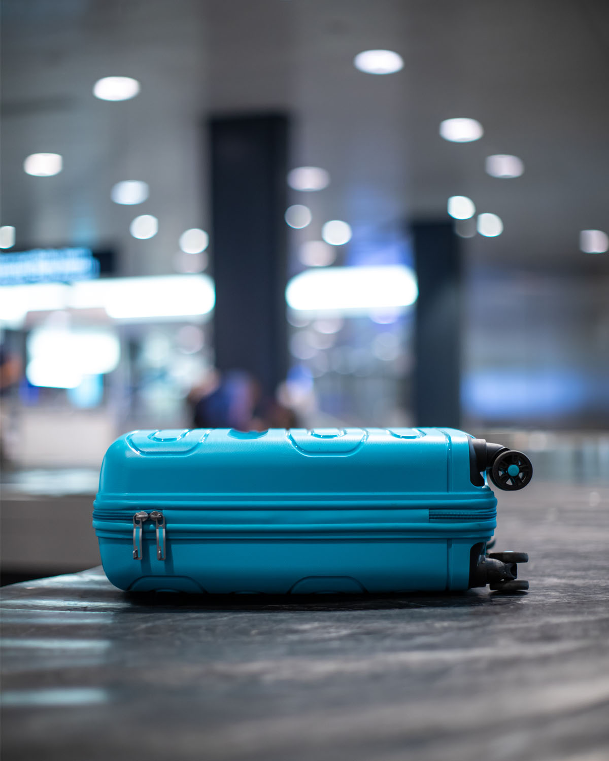 Coulisses d’un aéroport avec tapis à bagages et personnel au sol