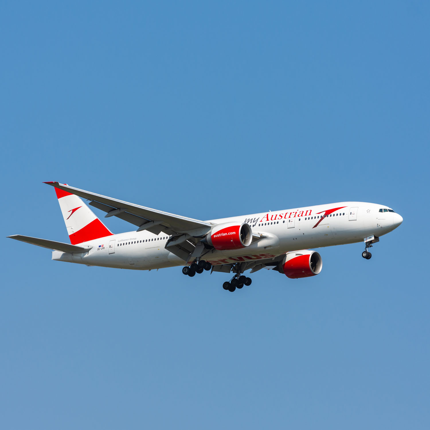 Avion Austrian Airlines au roulage, livrée blanche et rouge devant un terminal d’aéroport